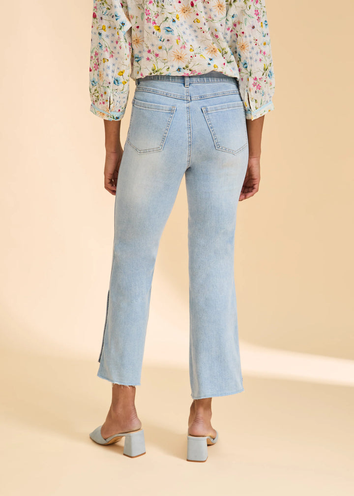 Light blue jeans worn by a person on a beige background