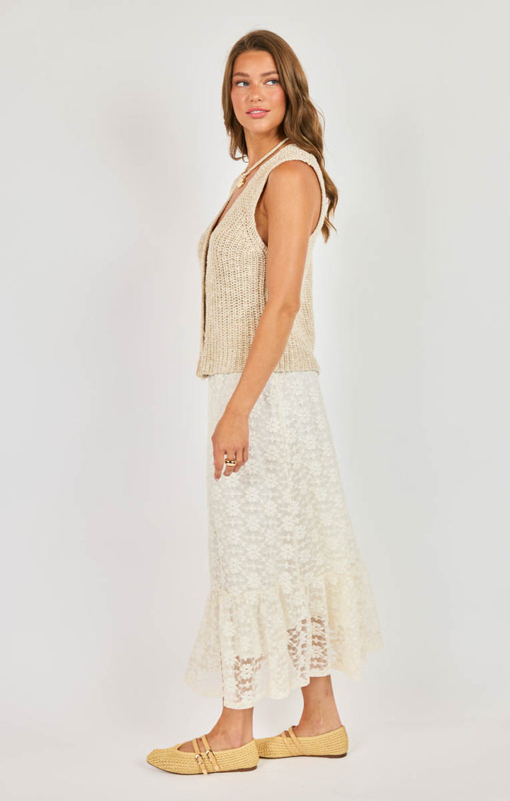 Woman wearing a sleeveless top and lace skirt on a white background