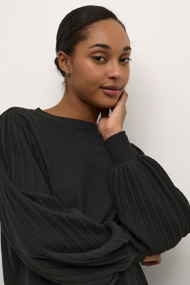 Woman wearing a black sweater against a white background