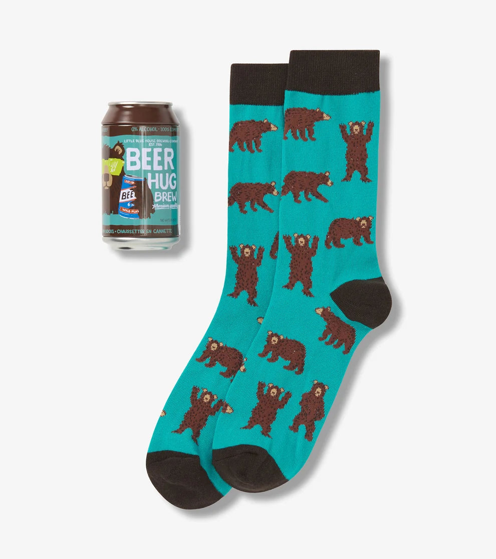 Teal socks with bear pattern next to a can of beer on a white background