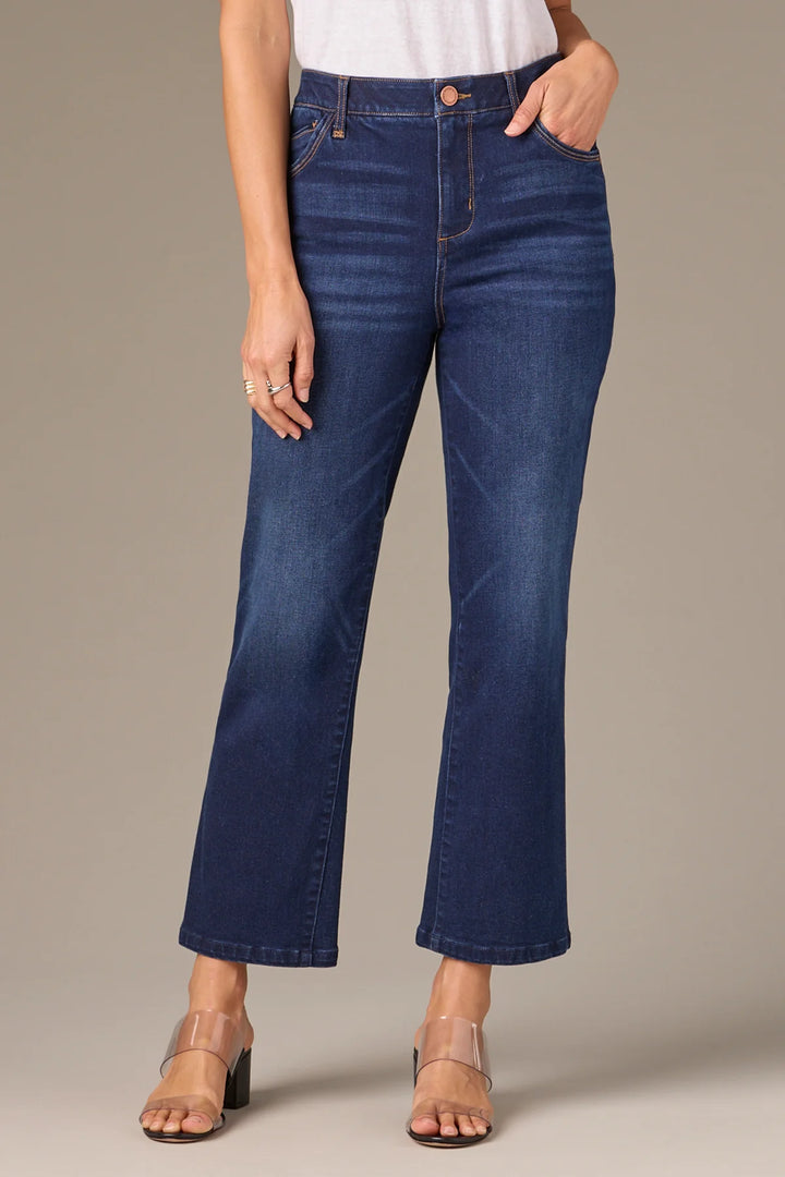 Person wearing blue jeans on a neutral background