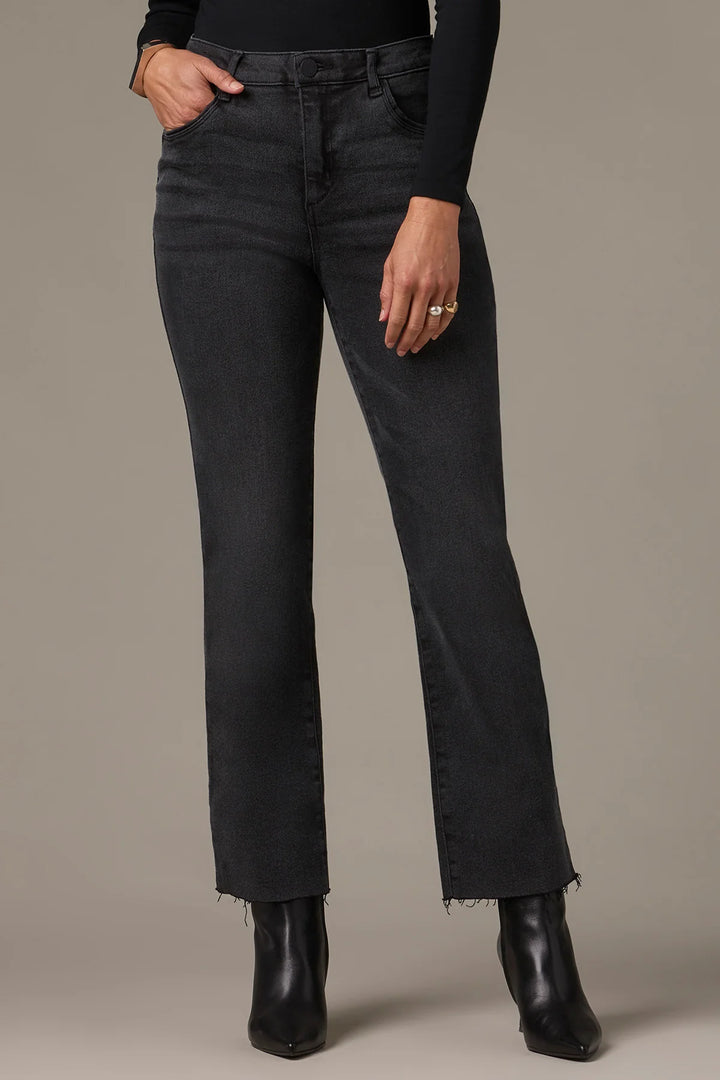 Person wearing black jeans and black boots on a plain background