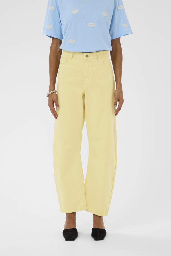 Person wearing a light blue top with yellow patterns and yellow pants on a white background