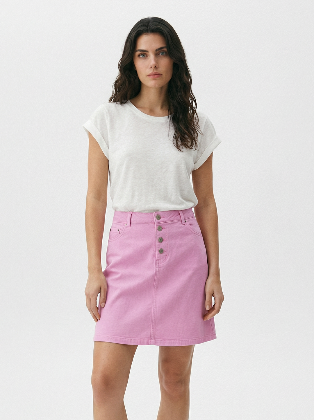 Woman wearing a white t-shirt and pink skirt on a white background