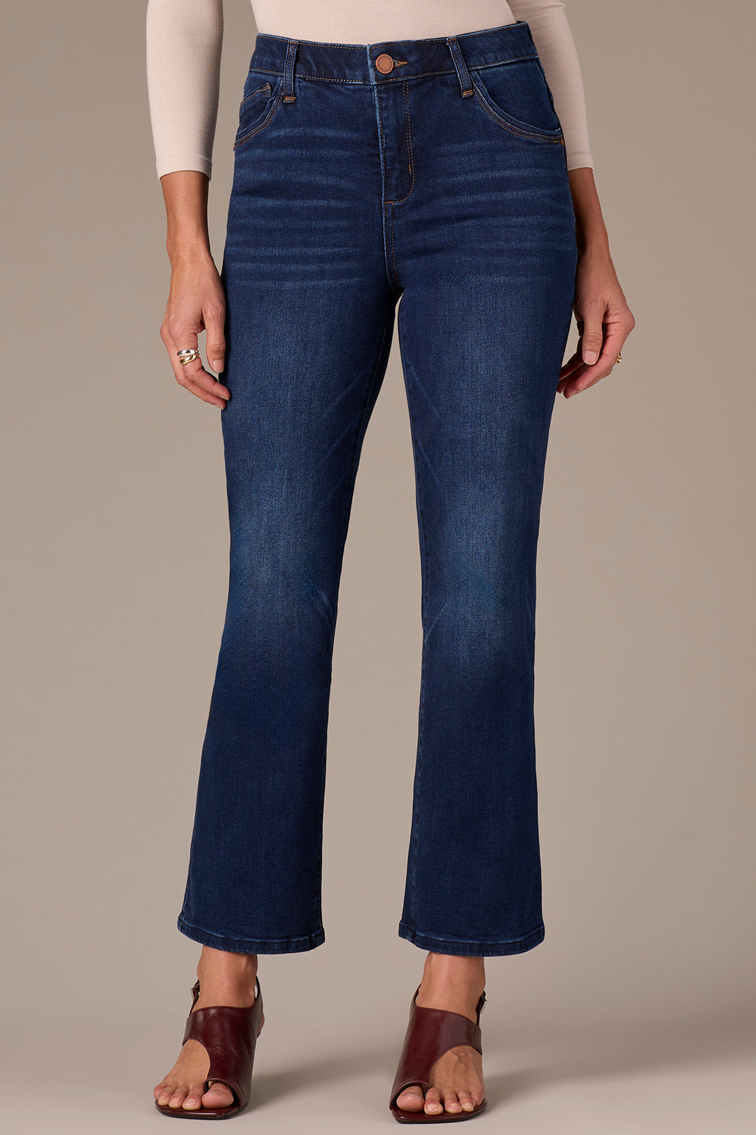 Person wearing blue jeans on a neutral background
