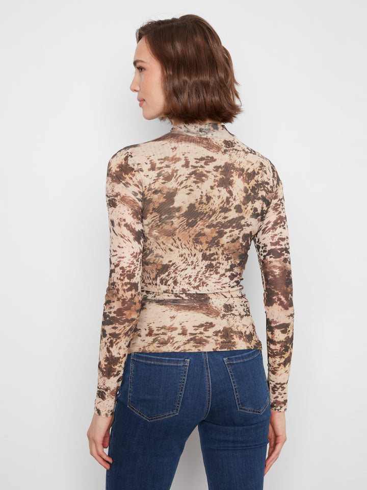 Woman wearing a camouflage long-sleeve top and blue jeans on a white background