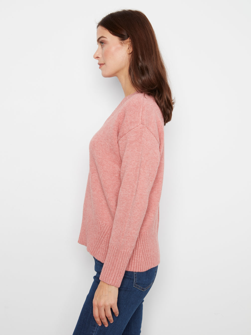Woman wearing a pink sweater against a white background