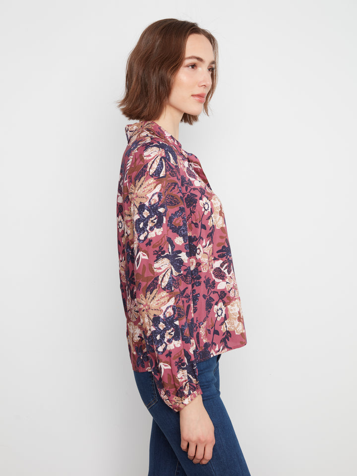 Woman wearing a floral blouse against a plain background