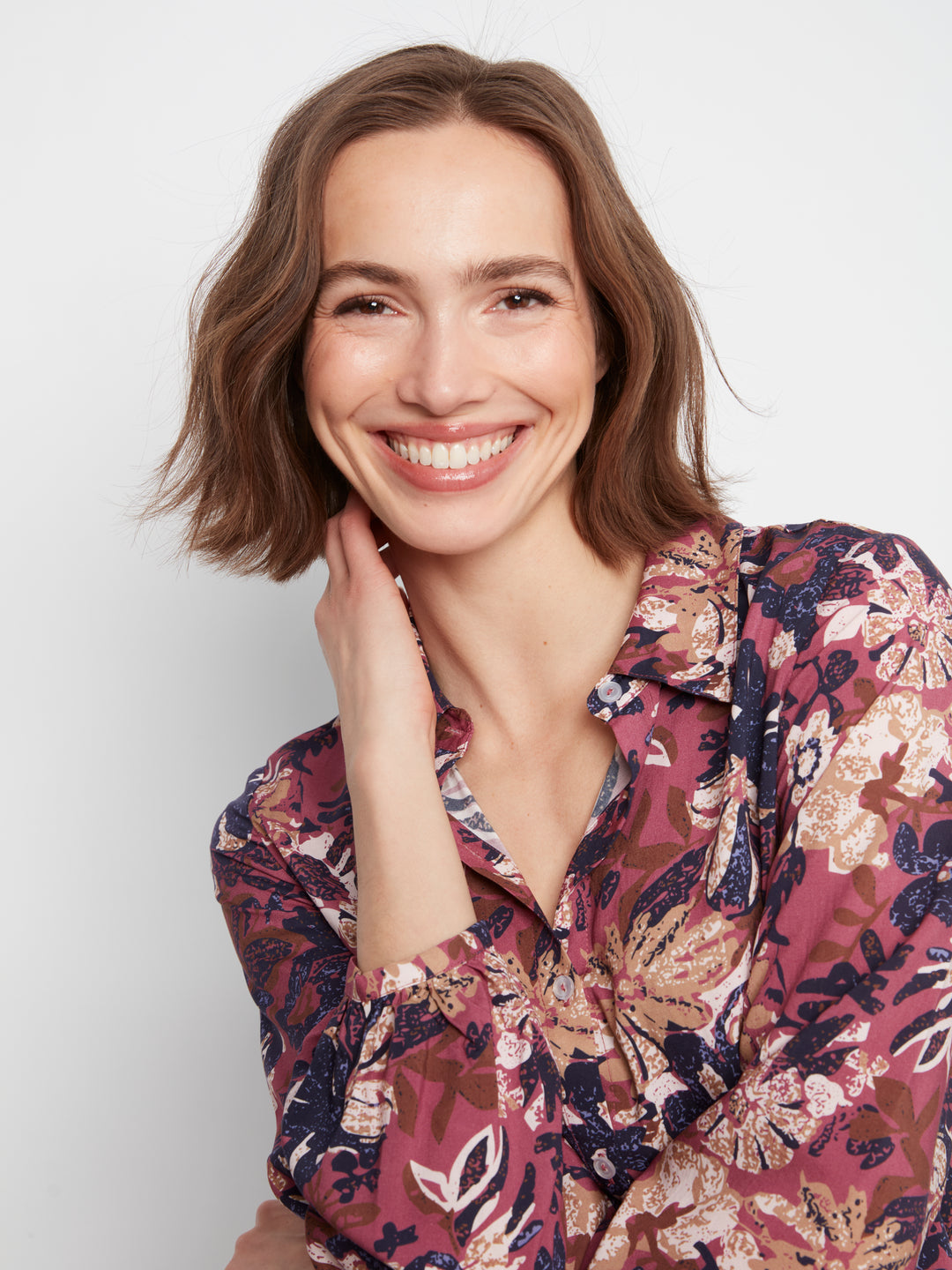 Woman wearing a floral blouse against a white background