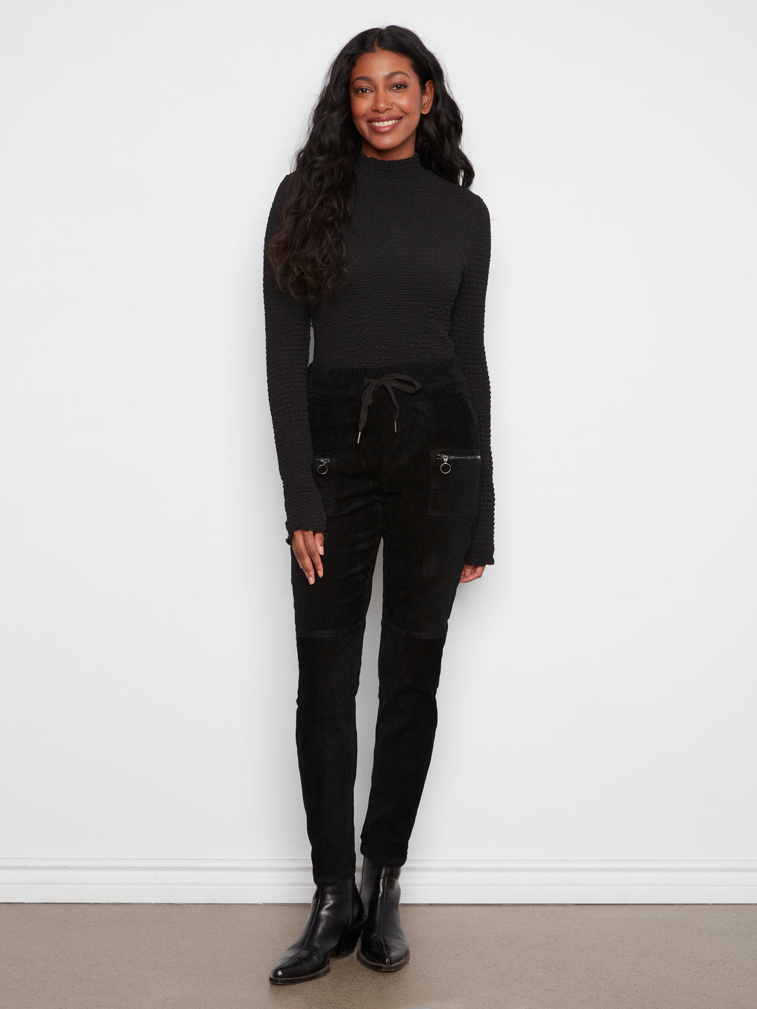 Woman wearing a black outfit against a white background
