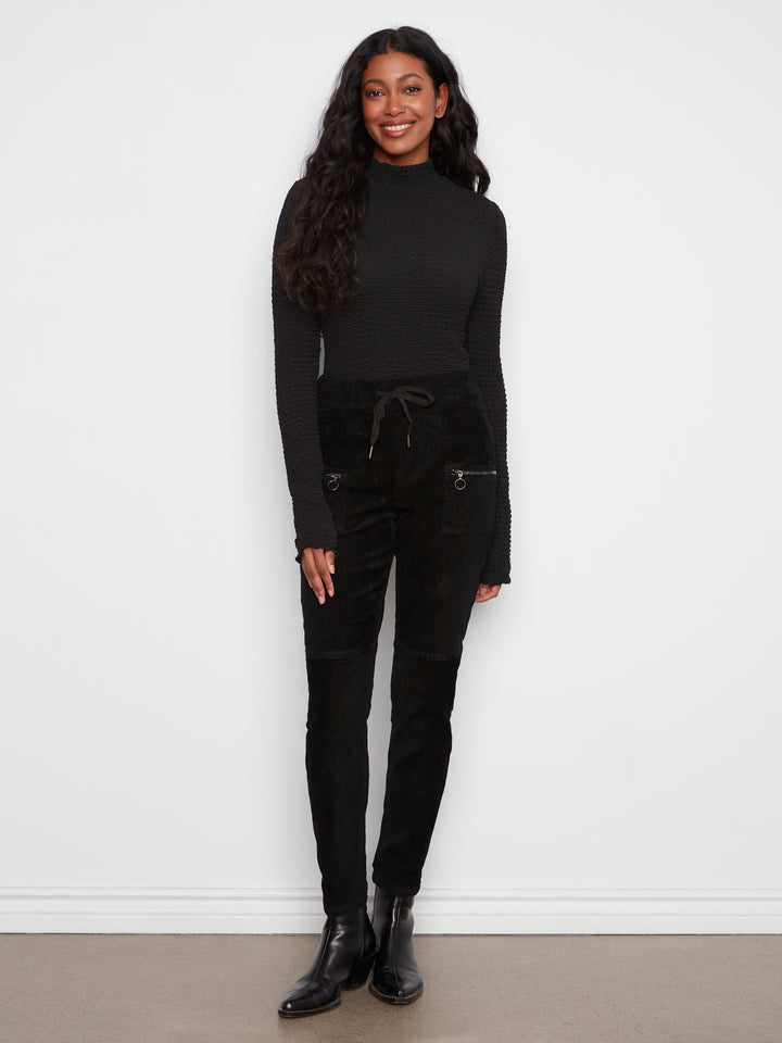Woman wearing a black outfit against a white background