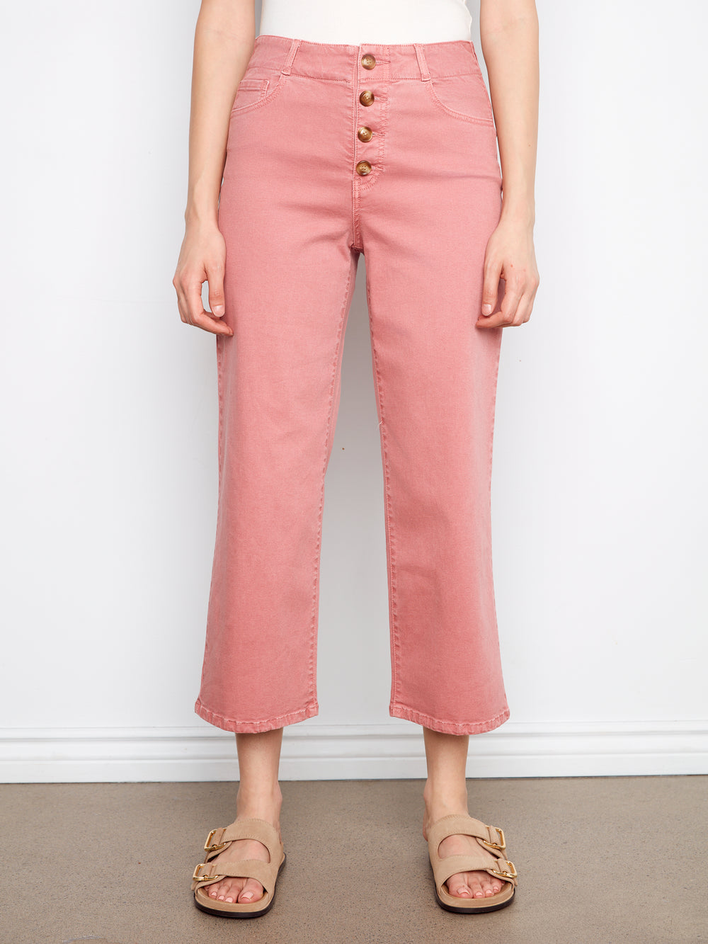 Person wearing pink jeans with a white background