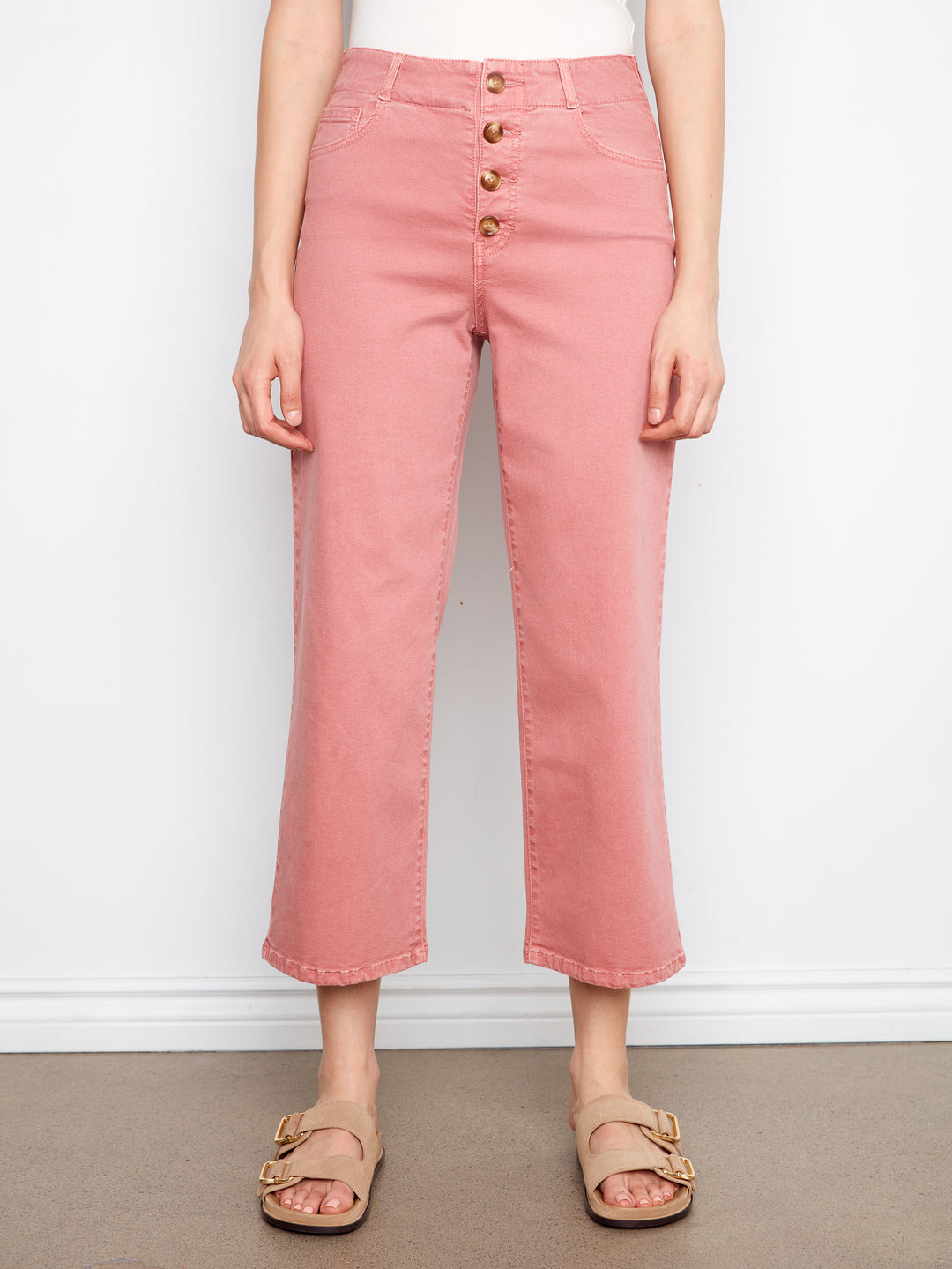 Person wearing pink jeans with a white background