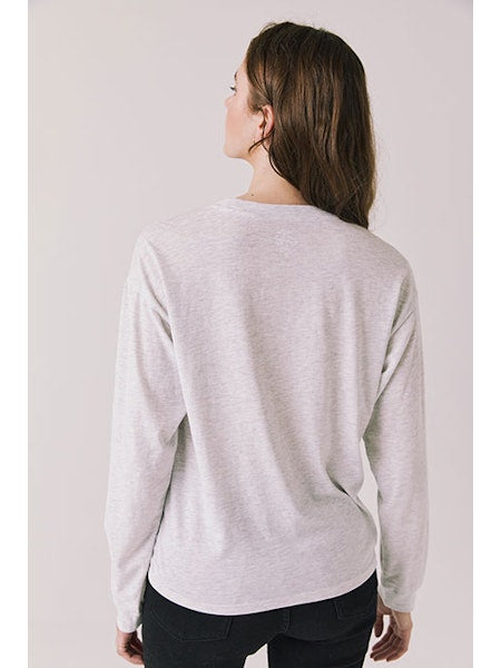 Person wearing a light gray sweater against a plain background