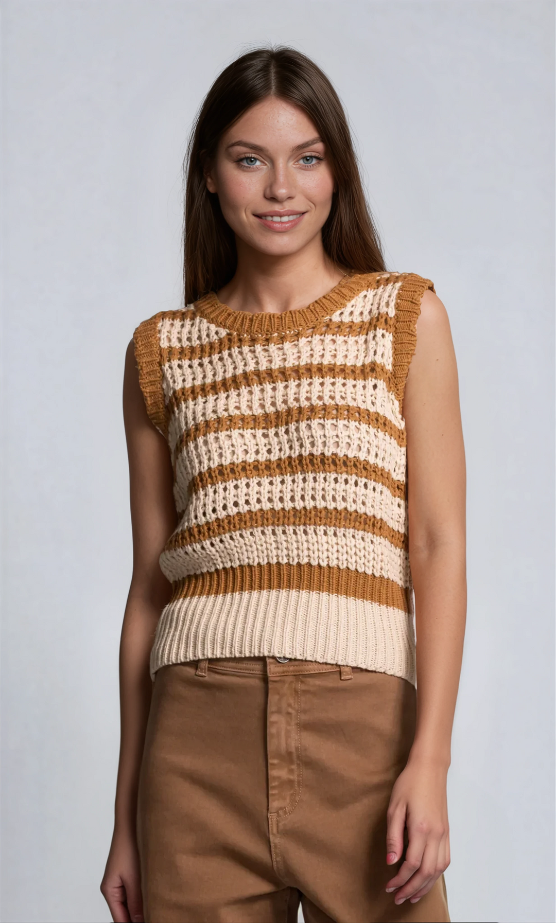 Woman wearing a brown and beige striped sleeveless sweater against a light gray background