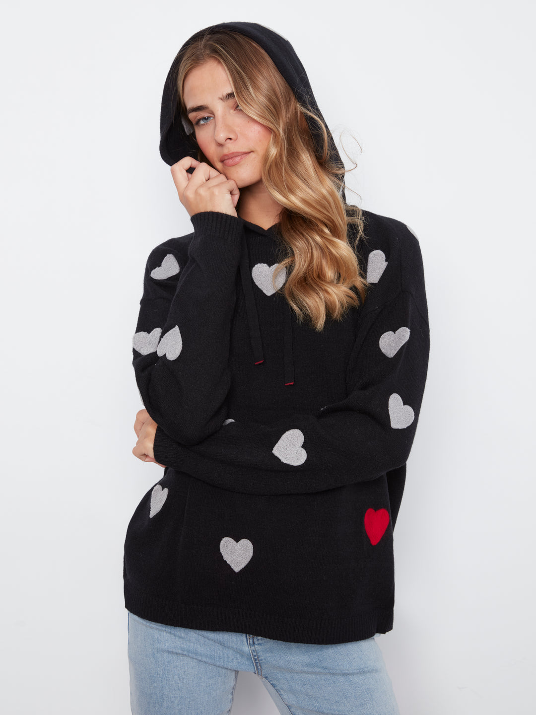 Woman wearing a black hoodie with heart patterns on a white background