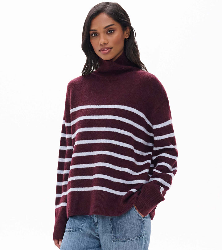 Woman wearing a maroon and white striped sweater on a white background