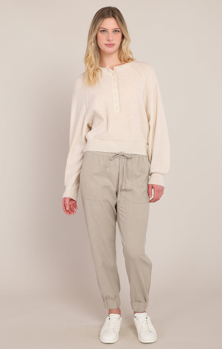 Woman wearing a beige outfit with a plain background