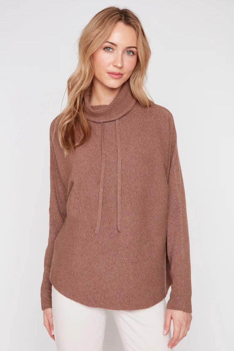 Woman wearing a brown sweater with a cowl neck on a white background