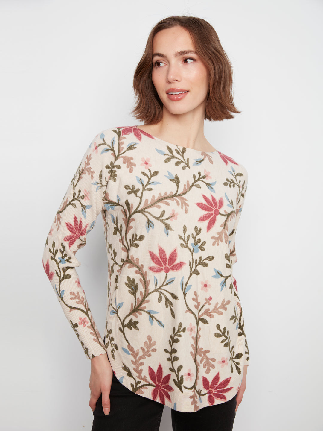 Woman wearing a floral-patterned long-sleeve top against a white background