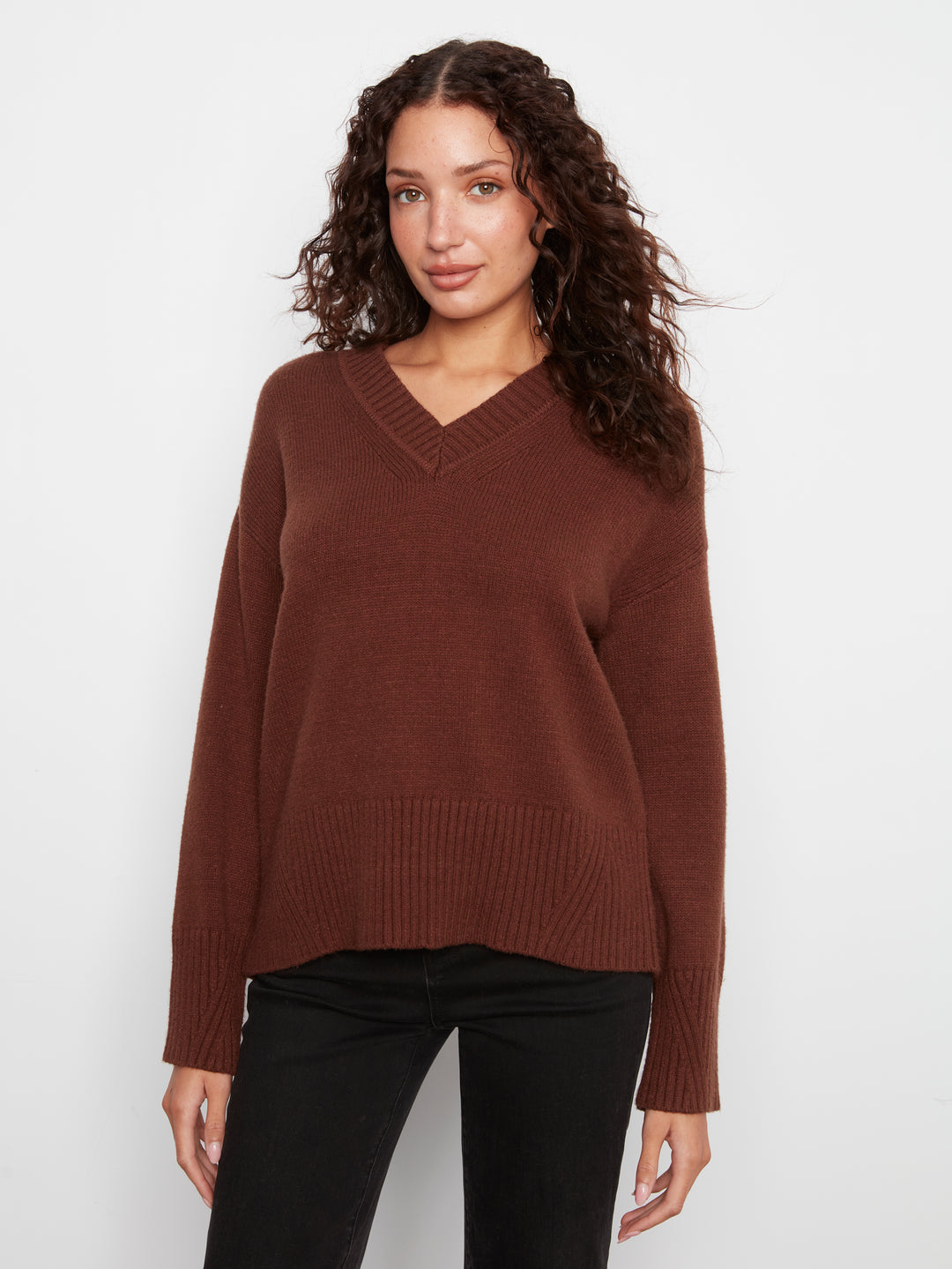 Woman wearing a brown sweater against a white background