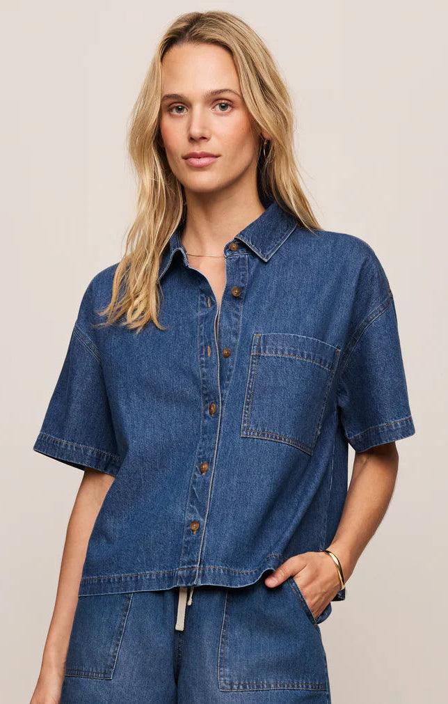 Woman wearing a blue denim outfit on a beige background