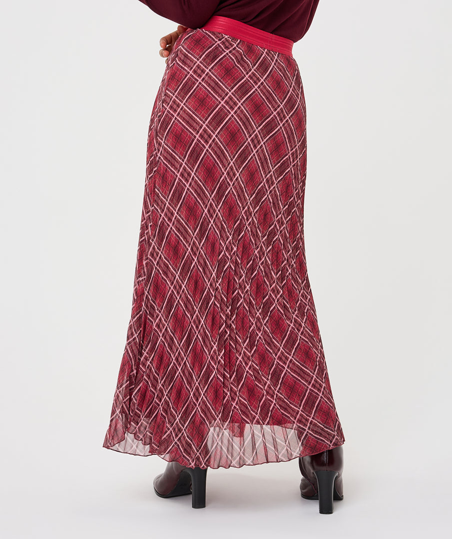 A red pleated maxi skirt with a white diamond grid pattern, shown on a model from the back against a light gray background.