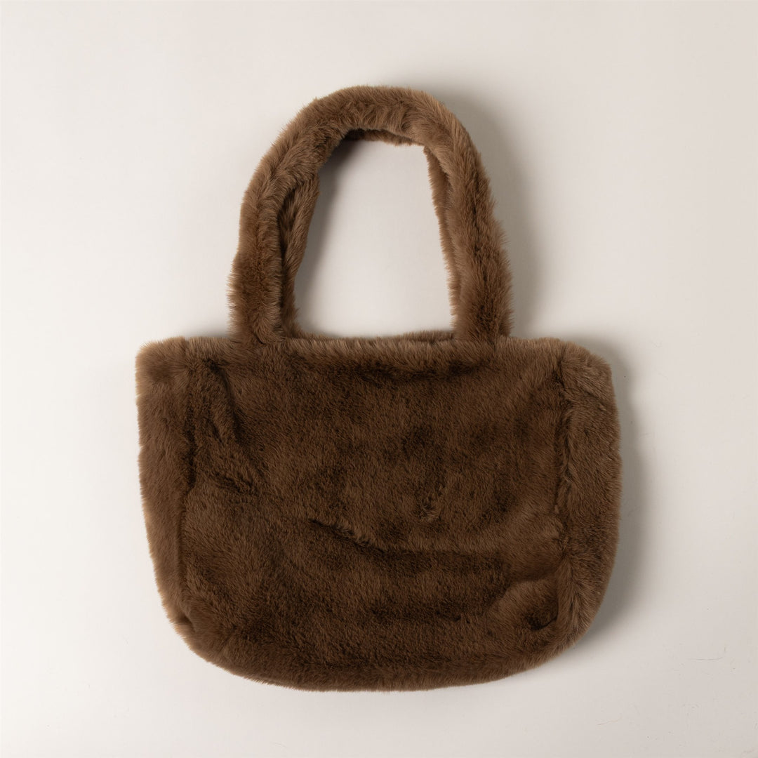 A small brown faux fur tote bag with two top handles, photographed against a plain light gray background.