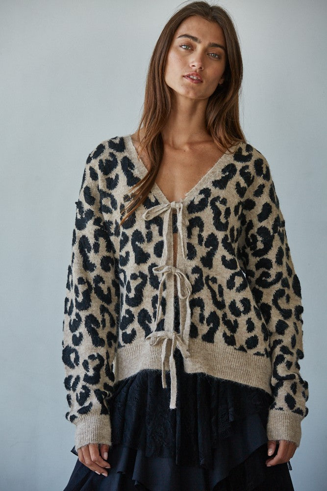 Woman wearing a leopard print sweater with a plain background