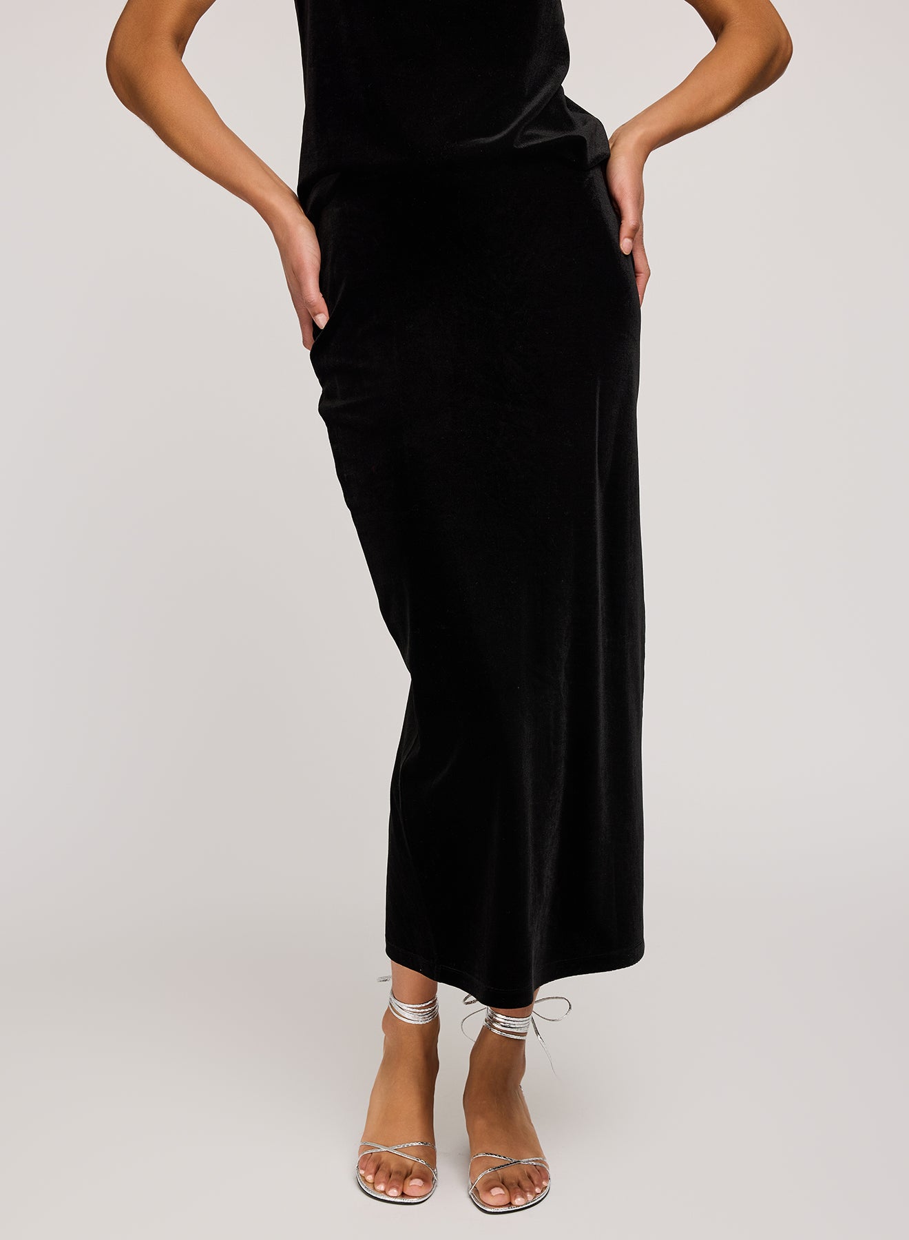 Person wearing a black dress with a plain background