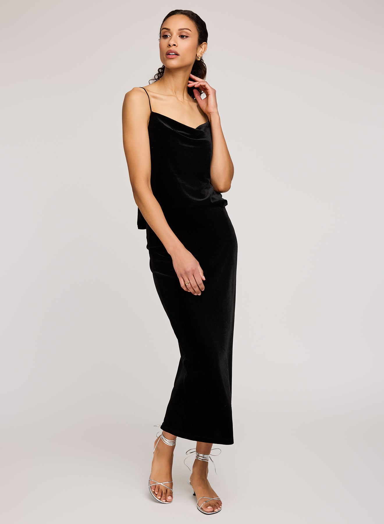 Woman wearing a black velvet dress on a plain background