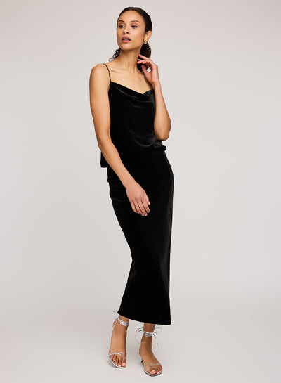 Woman wearing a black velvet dress on a plain background