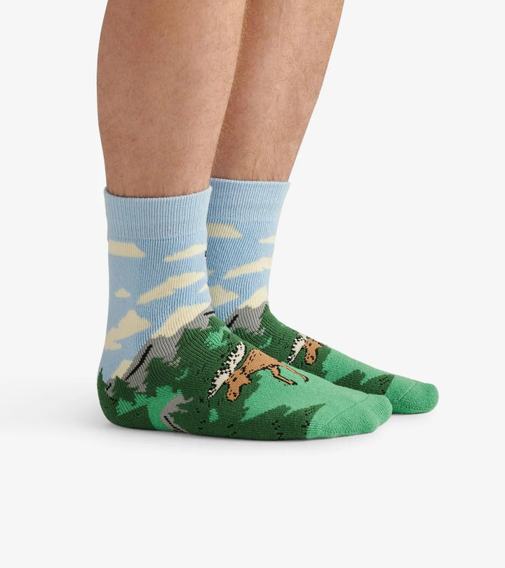 Green socks with animal pattern worn by a person on a white background