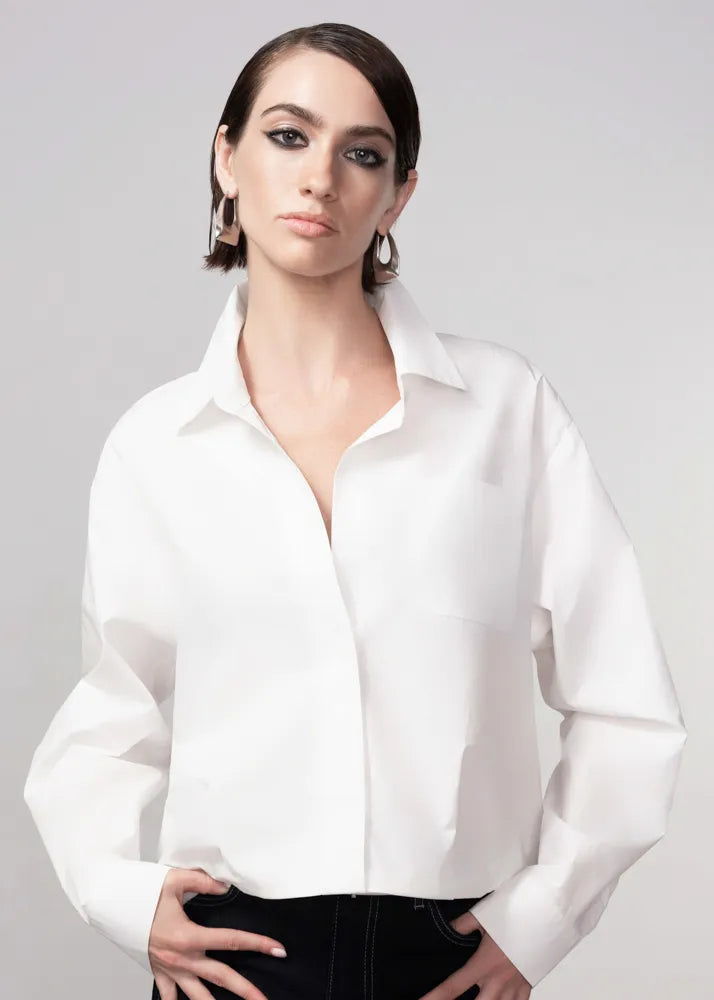 Woman wearing a white blouse against a plain background