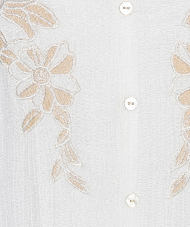 White shirt with beige floral embroidery on a light gray background