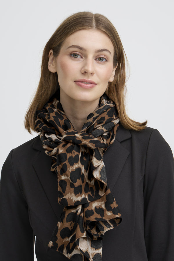 Woman wearing a leopard print scarf against a plain background