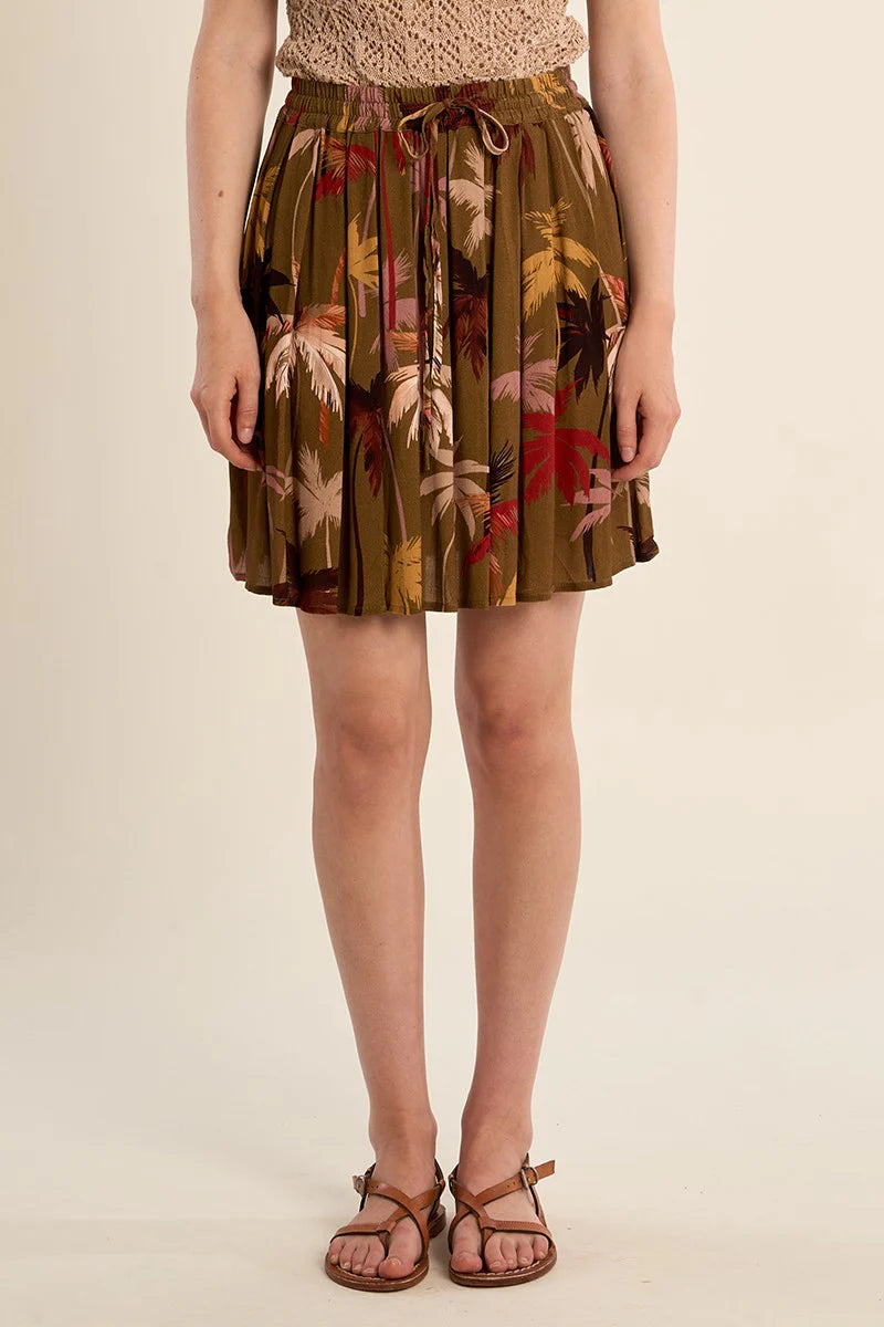 Woman wearing a floral skirt on a beige background