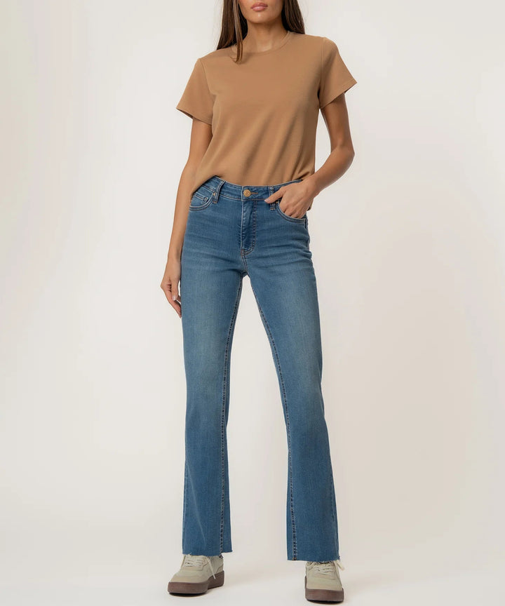 Person wearing a brown t-shirt and blue jeans on a white background