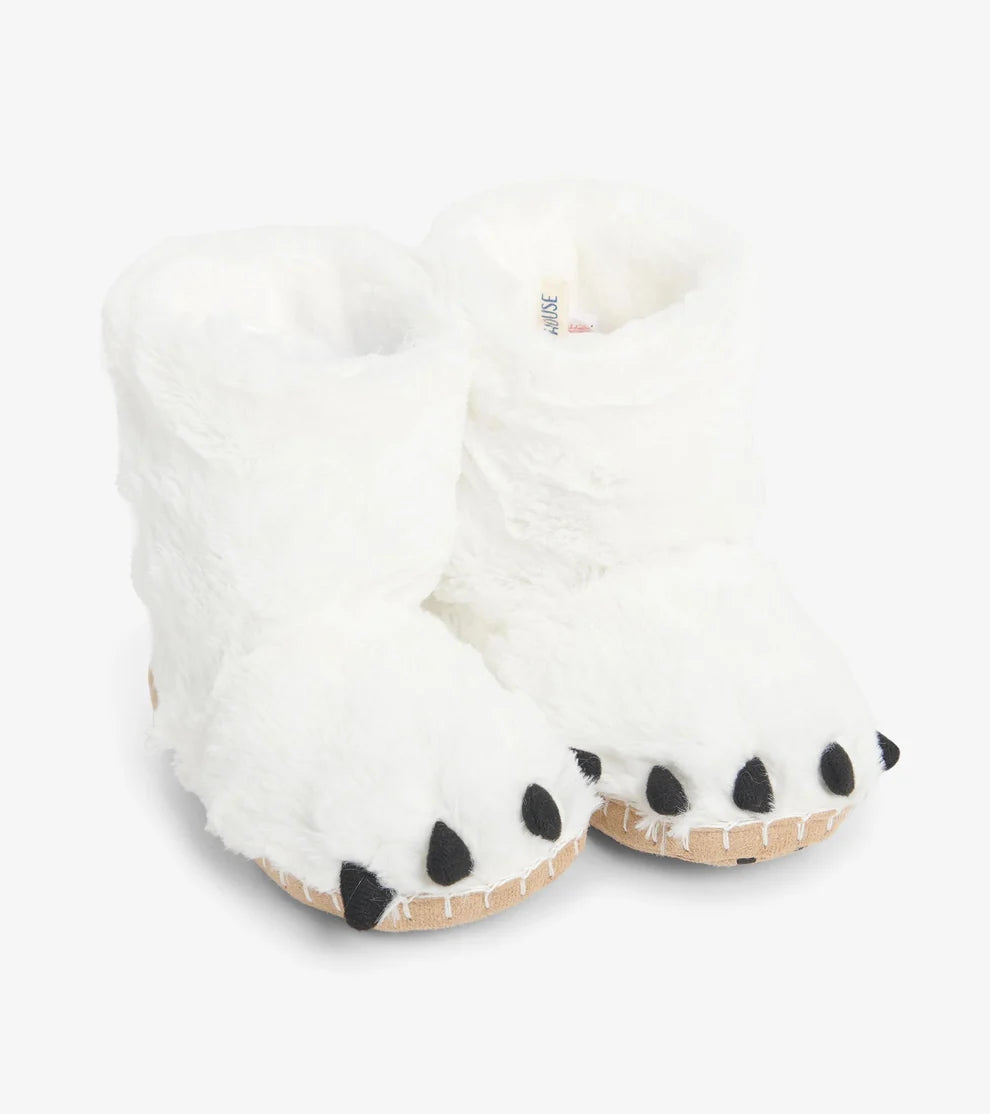 White fuzzy slippers with black paw prints on a white background