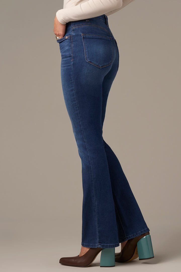 Blue flared jeans worn by a person on a neutral background