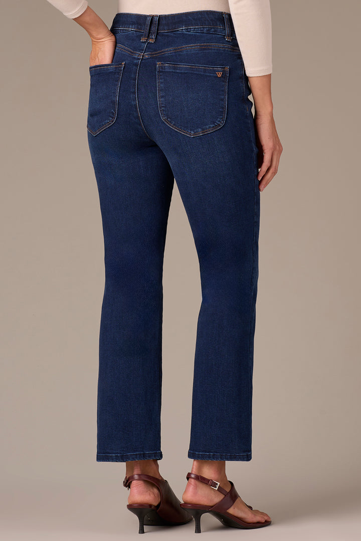 Blue jeans worn by a person on a beige background