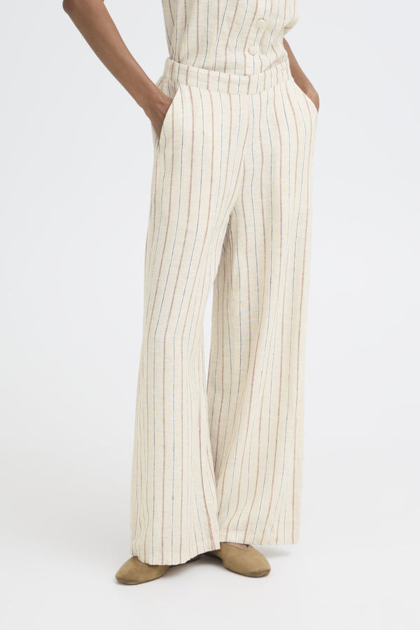 Person wearing a white and beige striped outfit with wide-leg pants on a white background