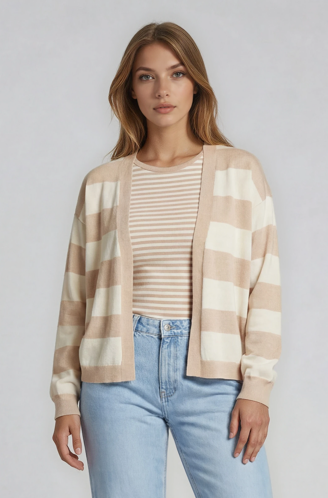 Woman wearing a plaid shirt, beige top, and light blue jeans on a white background