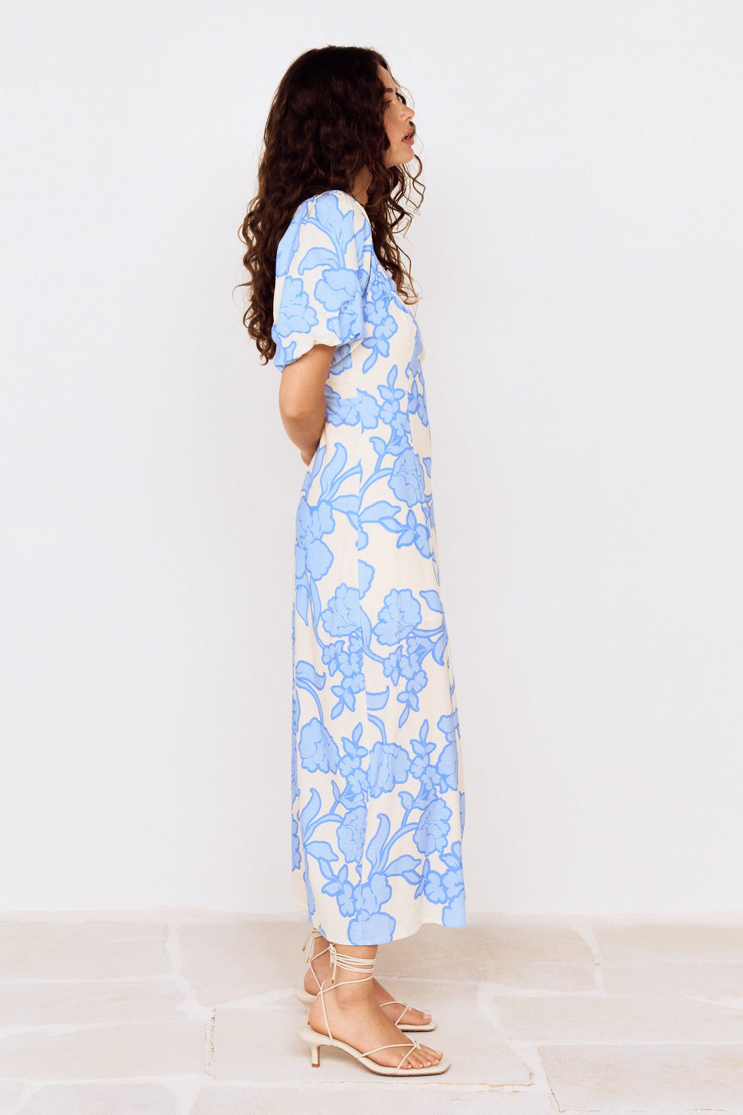 Woman wearing a blue floral dress on a white background