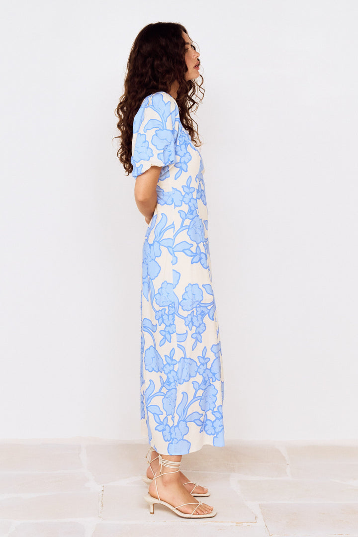 Woman wearing a blue floral dress on a white background