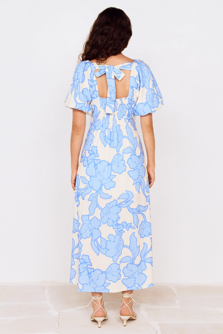 Woman wearing a blue floral dress on a white background