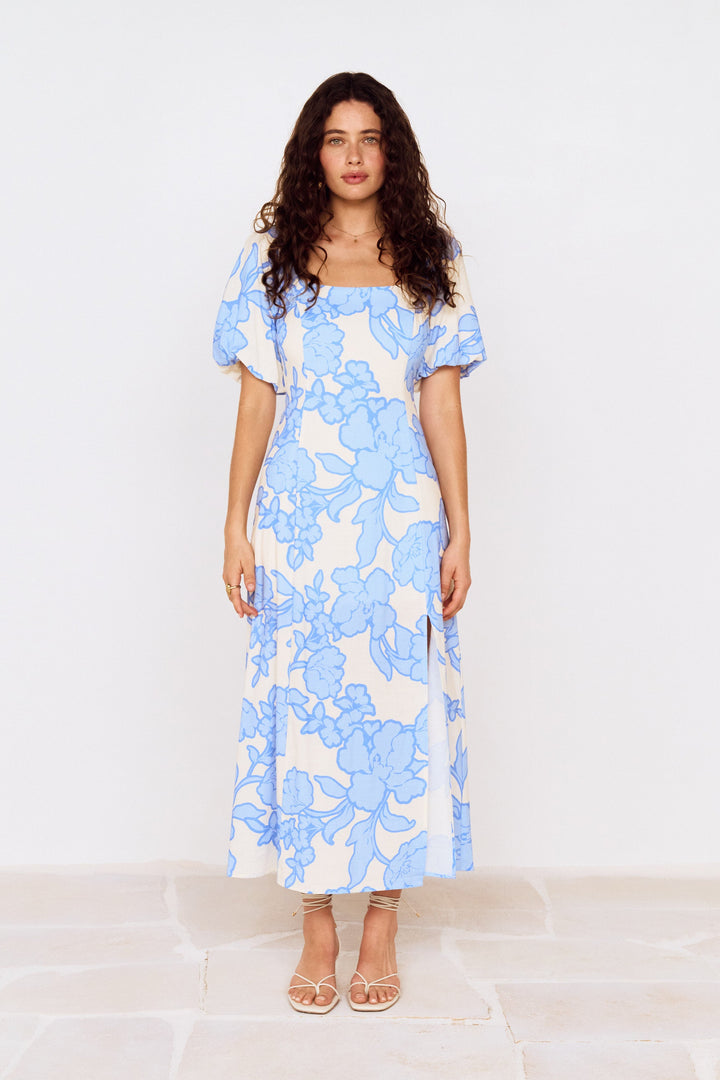 Woman wearing a blue floral dress on a white background