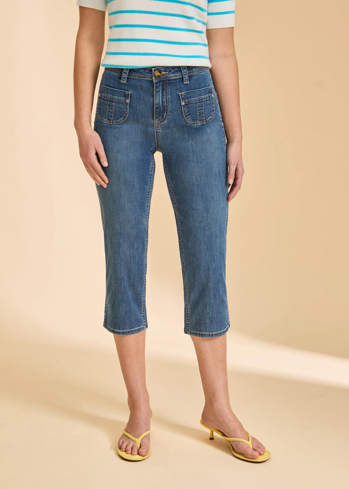 Person wearing blue jeans and a striped shirt on a beige background