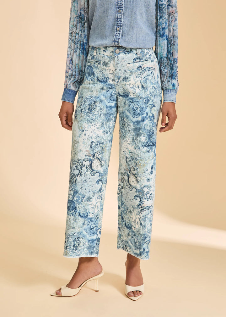Person wearing blue floral pants with a beige background