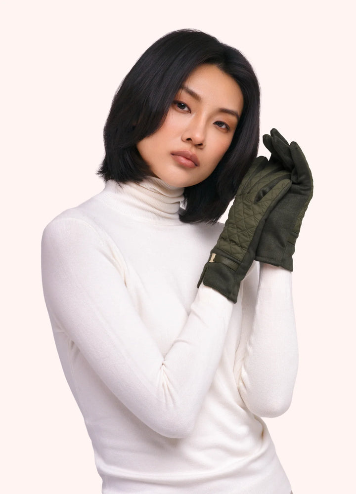 Woman wearing a white turtleneck and green gloves on a white background